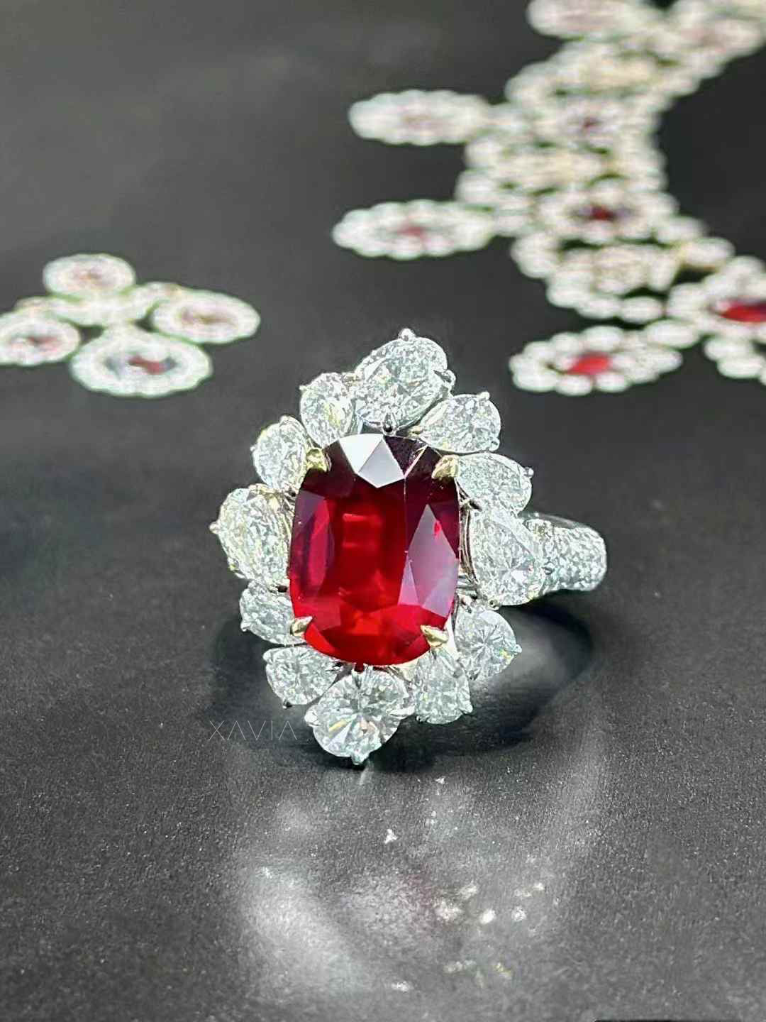Ring with a red gemstone and diamond-like stones on a dark surface