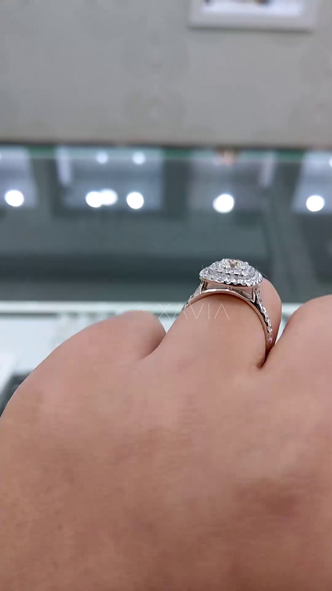 side profile of elevated double halo engagement ring with visible gallery structure and pavé set band crafted in white gold