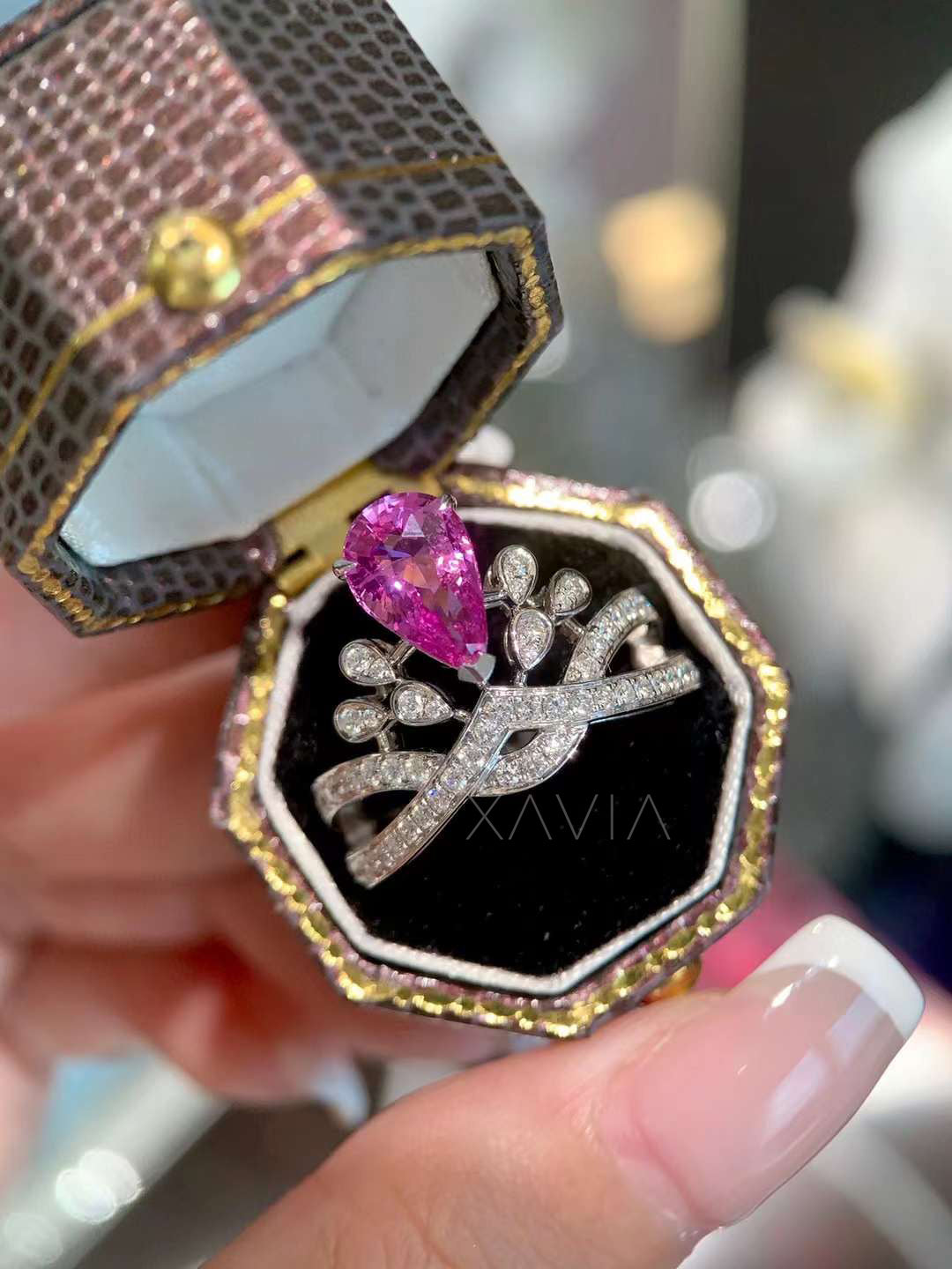 pear cut lab grown pink diamond engagement ring displayed in luxury box with marquise floral halo and pavé twisted band