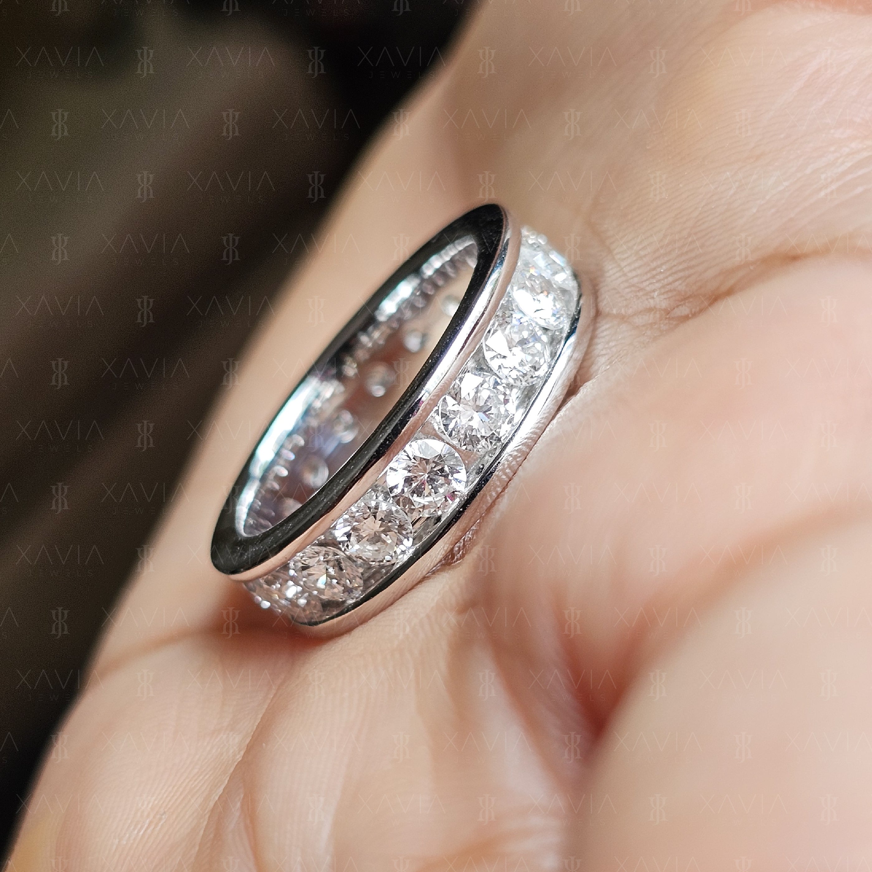 Angled luxury view of round brilliant lab-grown diamond eternity band with modern wide profile and smooth reflective metal finish