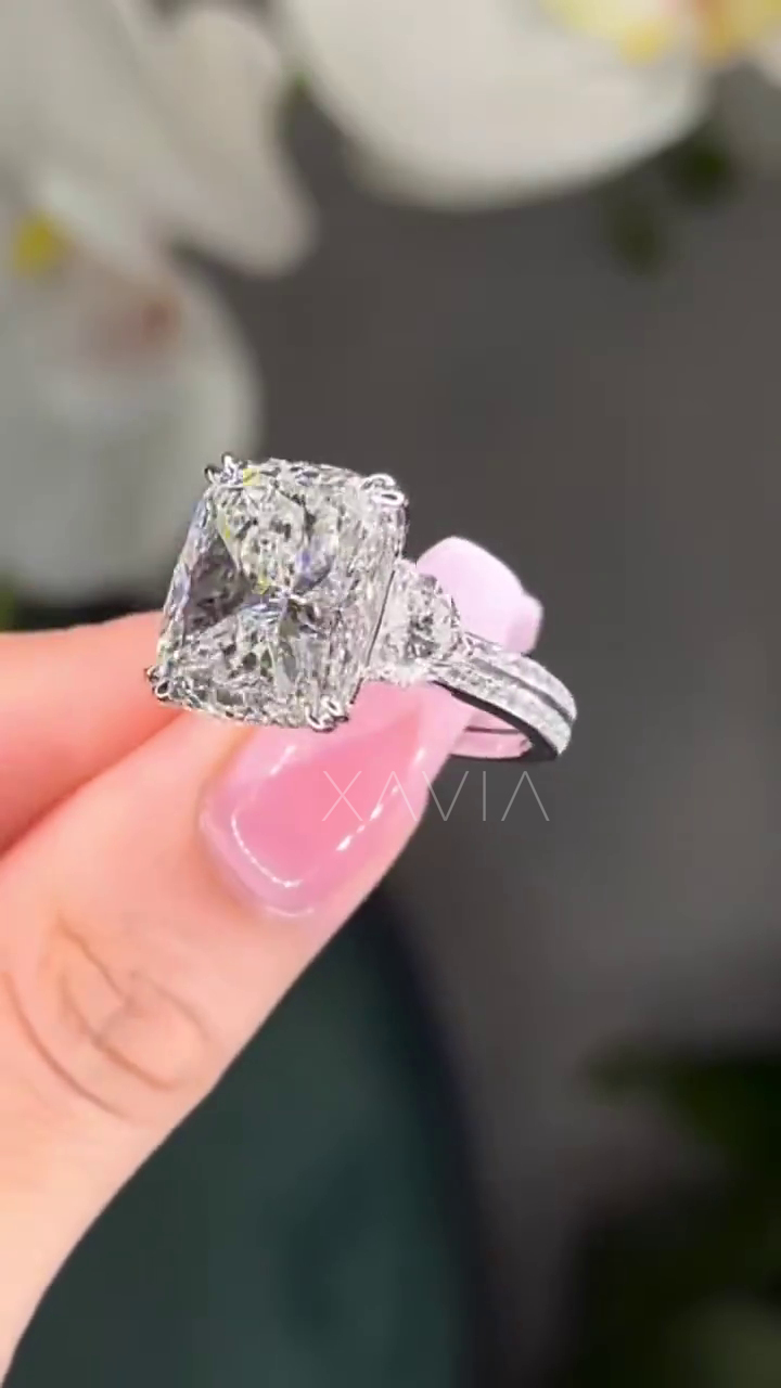 angled close-up of cushion cut lab diamond engagement ring with trapezoid side stones and pavé platinum band