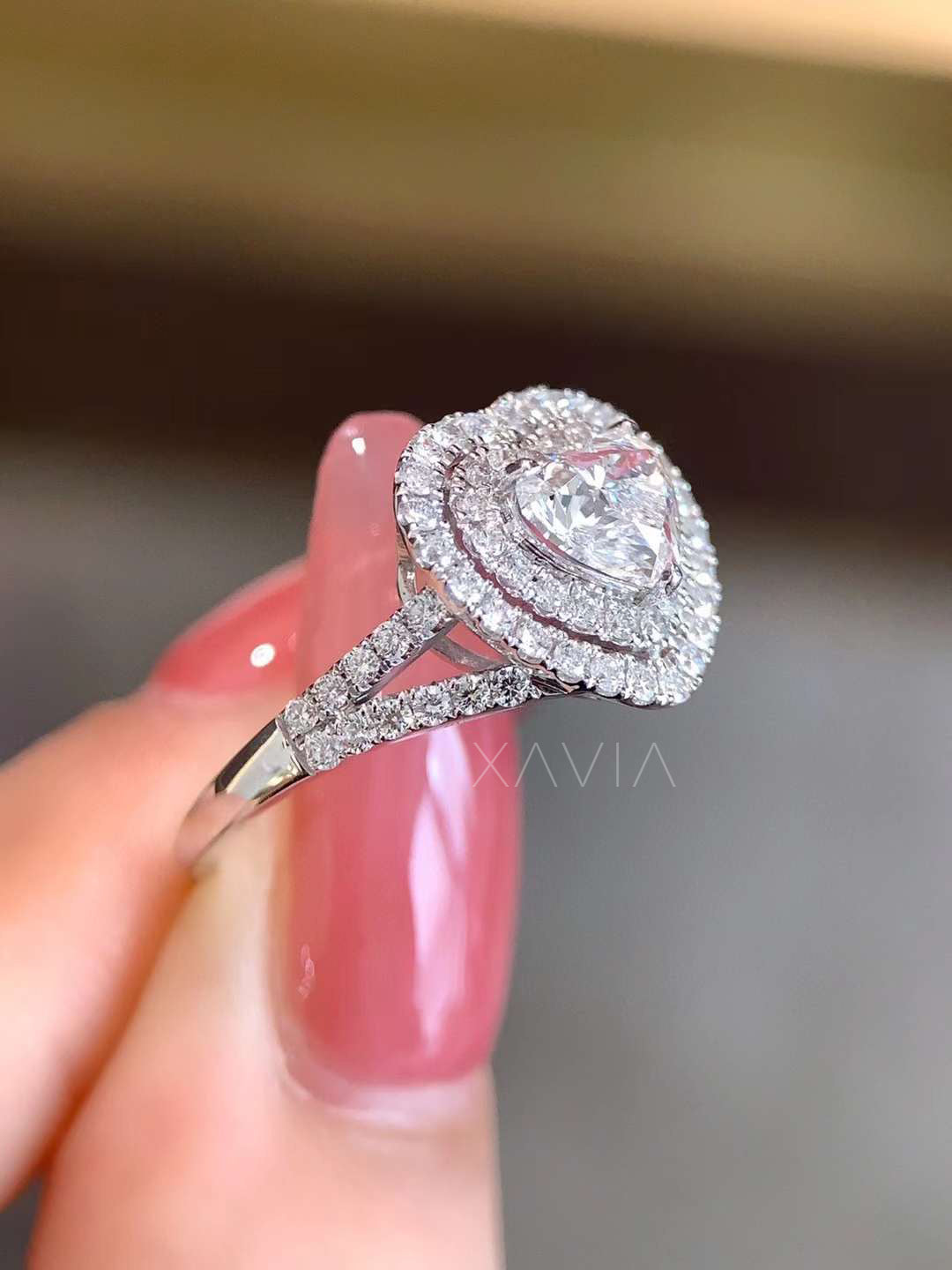 angled perspective of heart cut halo engagement ring in white gold with pavé diamonds on split shank