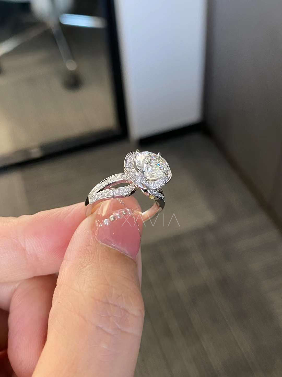 angled close-up of round halo engagement ring featuring split shank pavé diamonds in platinum