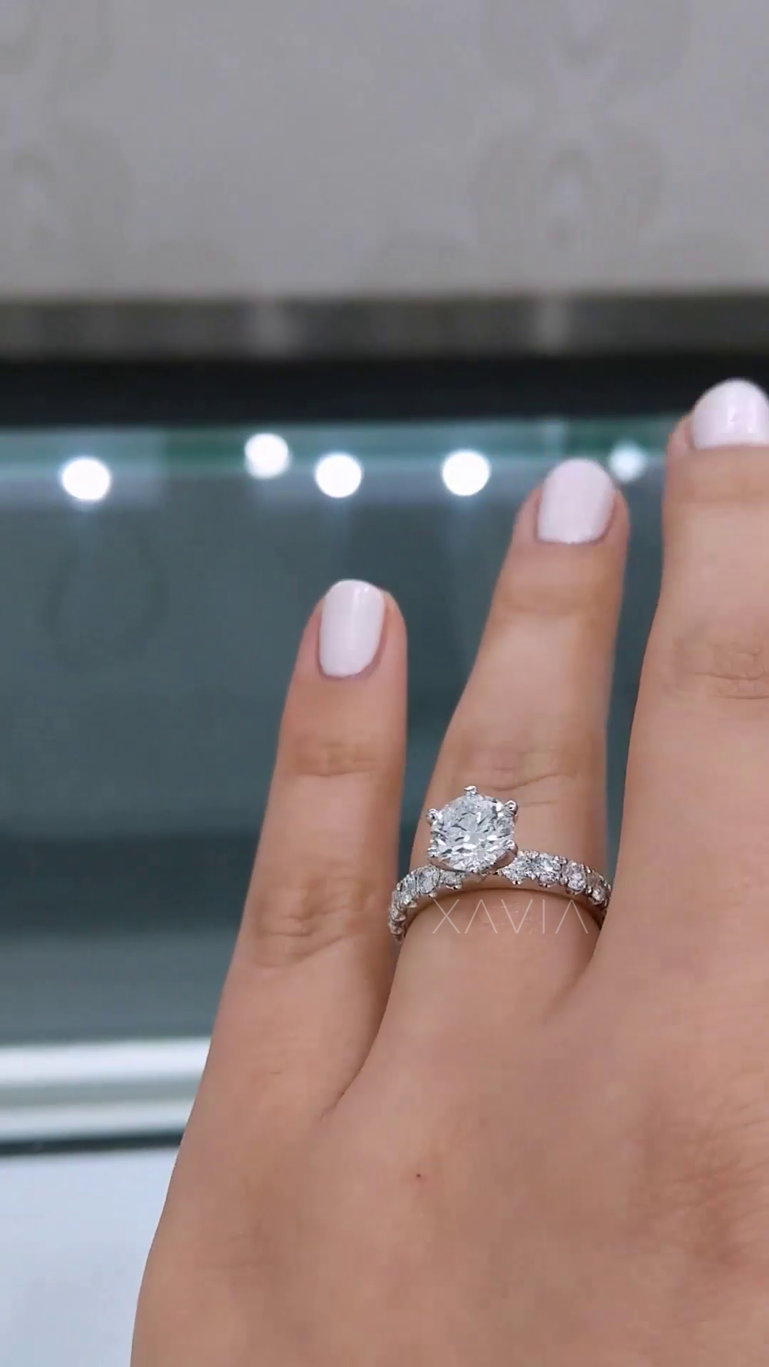 angled perspective of round brilliant lab diamond engagement ring with pavé band showing elevated solitaire crown setting and continuous sparkle on finger