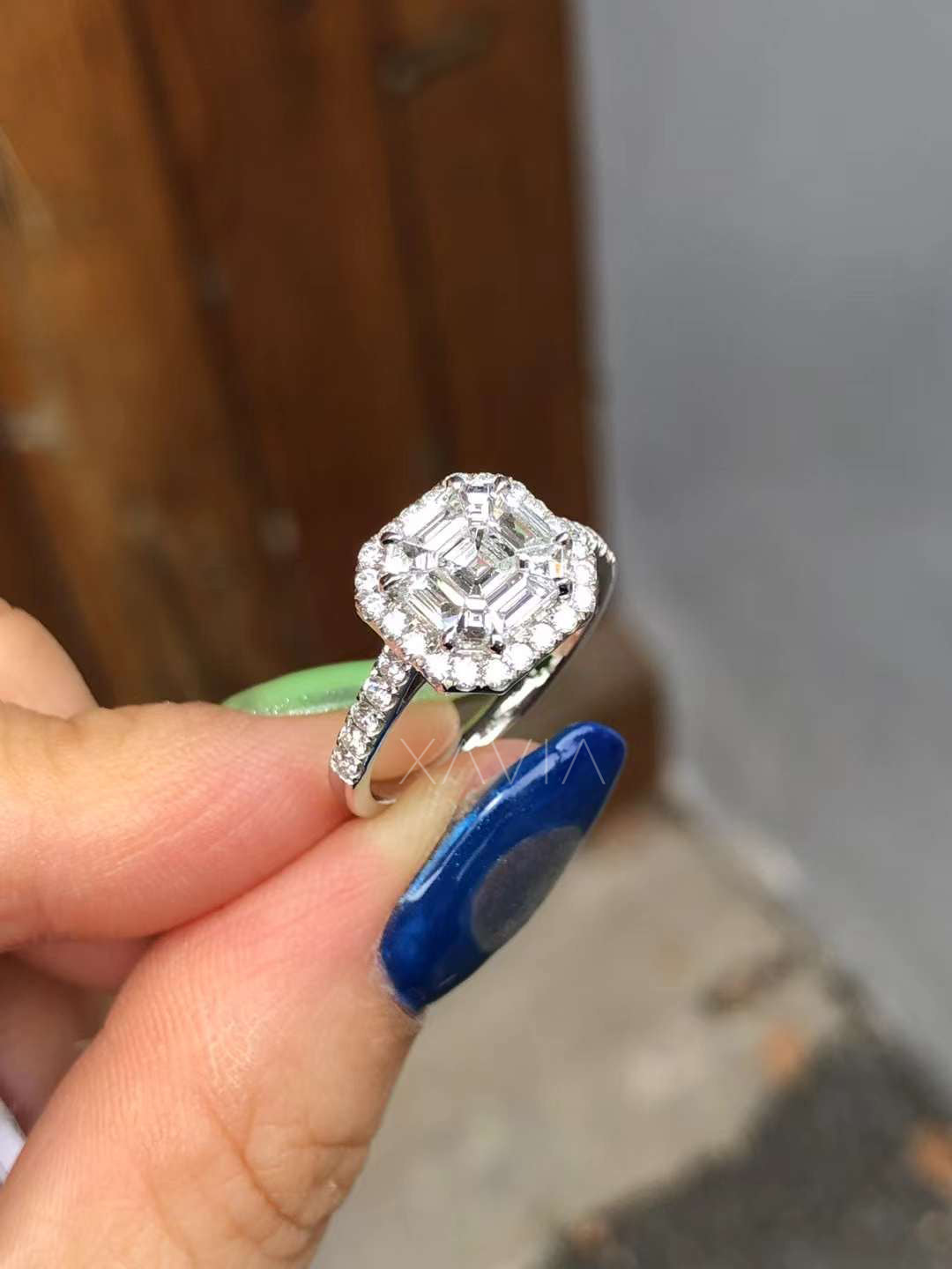 angled side view showing pavé diamond band and structured halo with baguette and round diamonds around asscher center stone