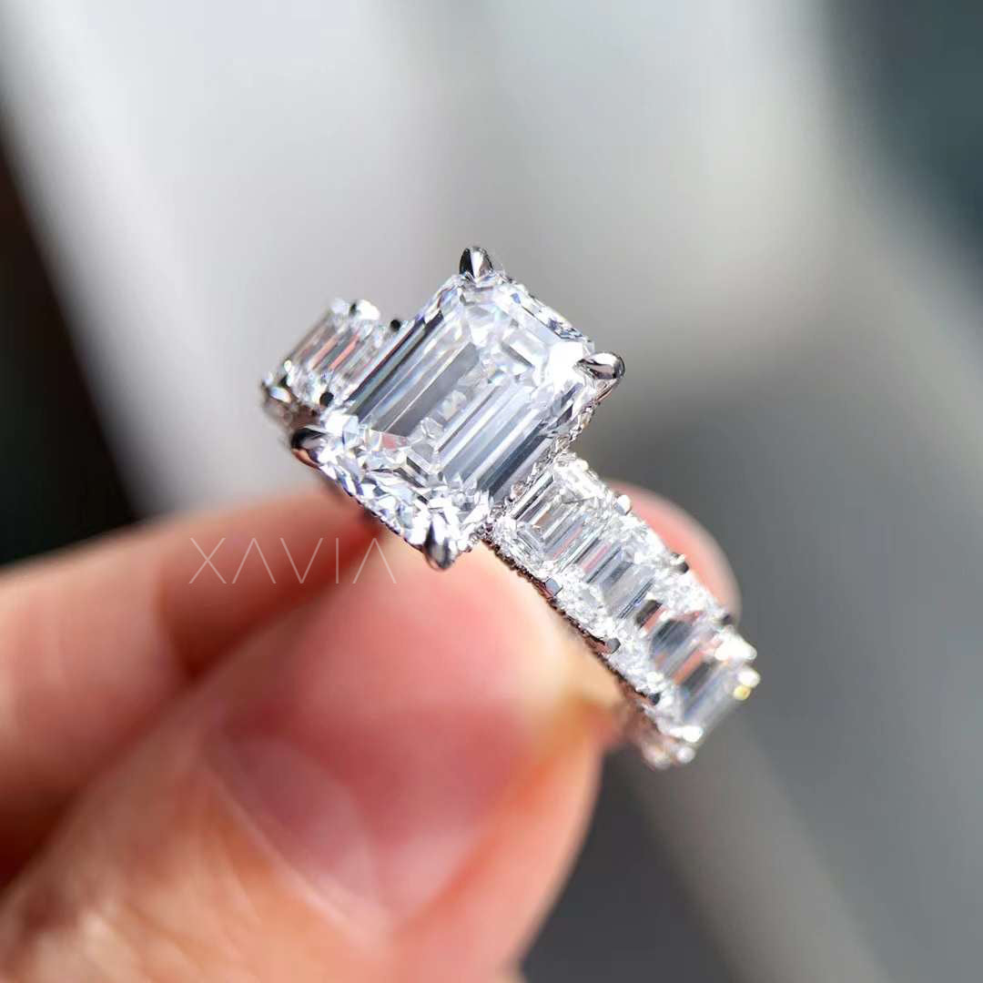 close-up side view of baguette diamond band with emerald cut center