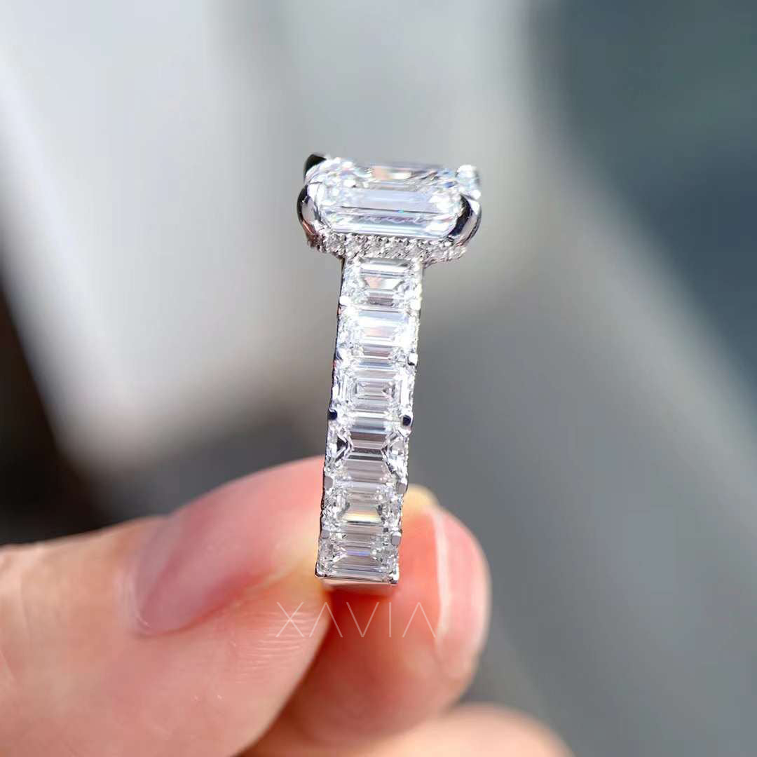 close-up side view of baguette diamond band with emerald cut center