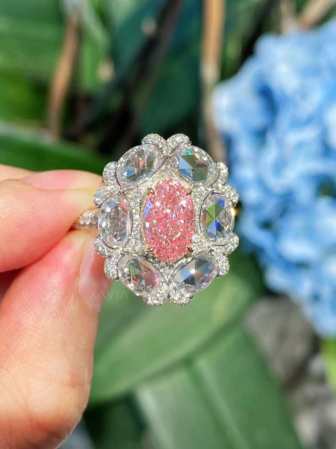 close-up view of Calyssia fancy pink oval diamond cocktail ring with rose-cut floral halo and pavé band in platinum