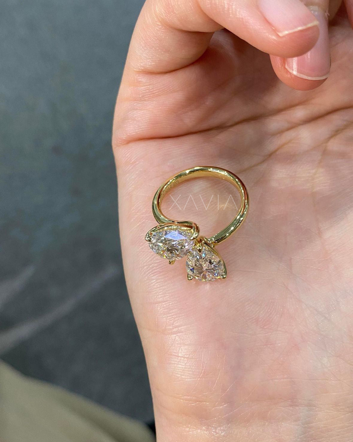 closeup of yellow gold ring with two pear cut lab diamonds