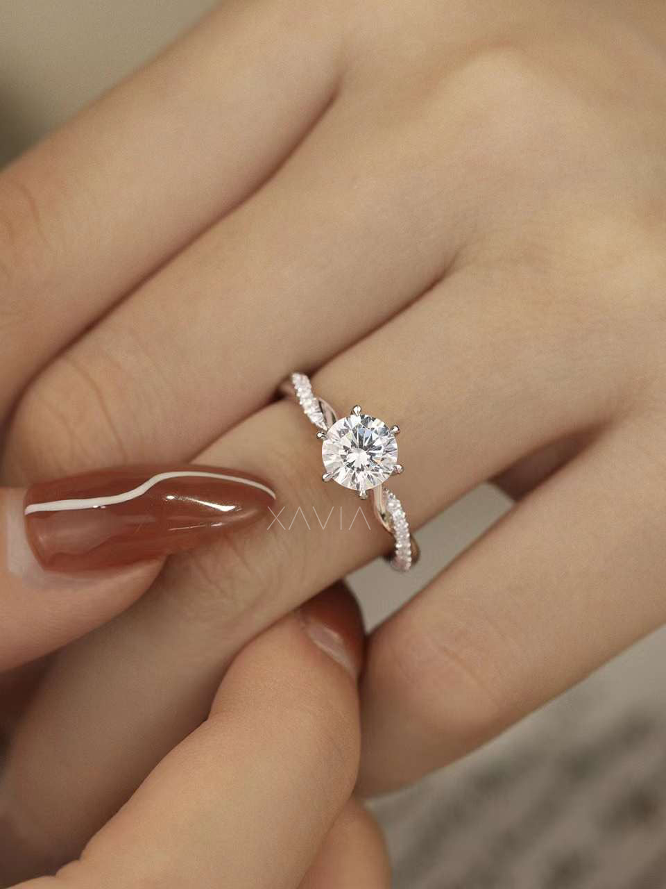 Close-up view of solitaire round cut diamond engagement ring with pavé twisted band in white gold setting