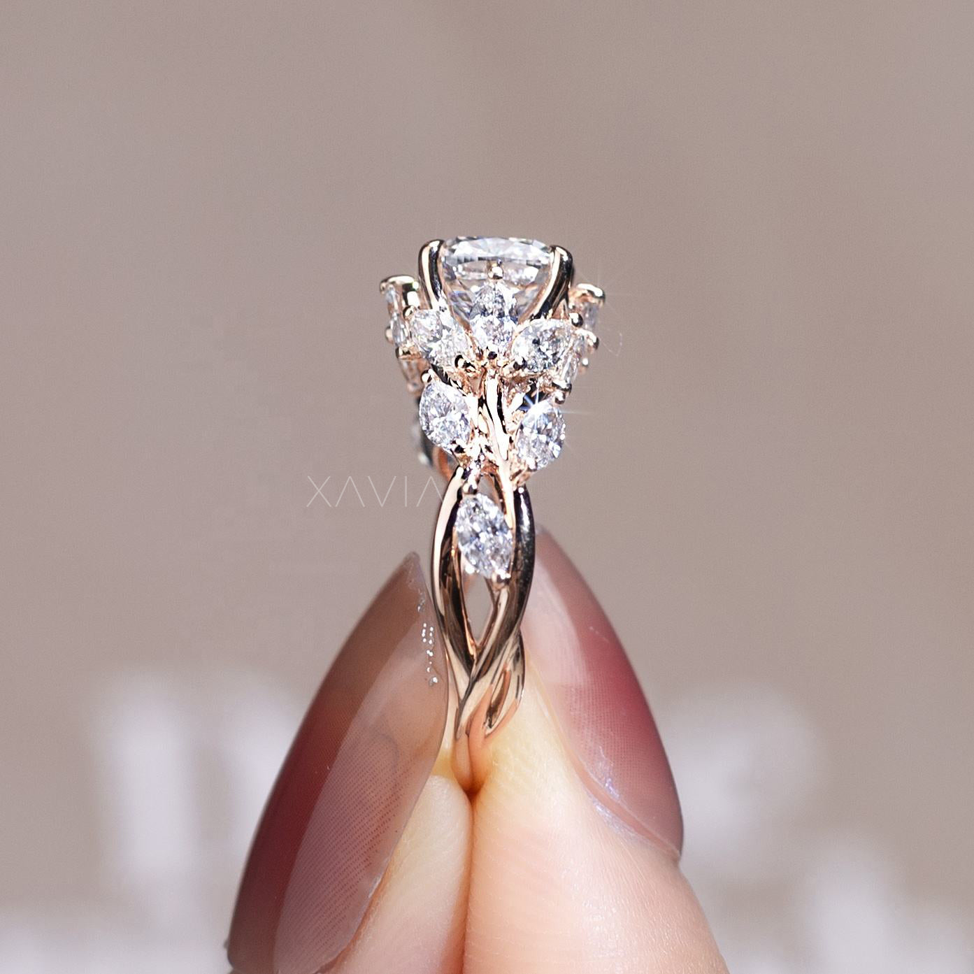 close view of cushion cut lab grown diamond engagement ring held between fingers showing floral cluster design with marquise and baguette diamonds in rose gold band