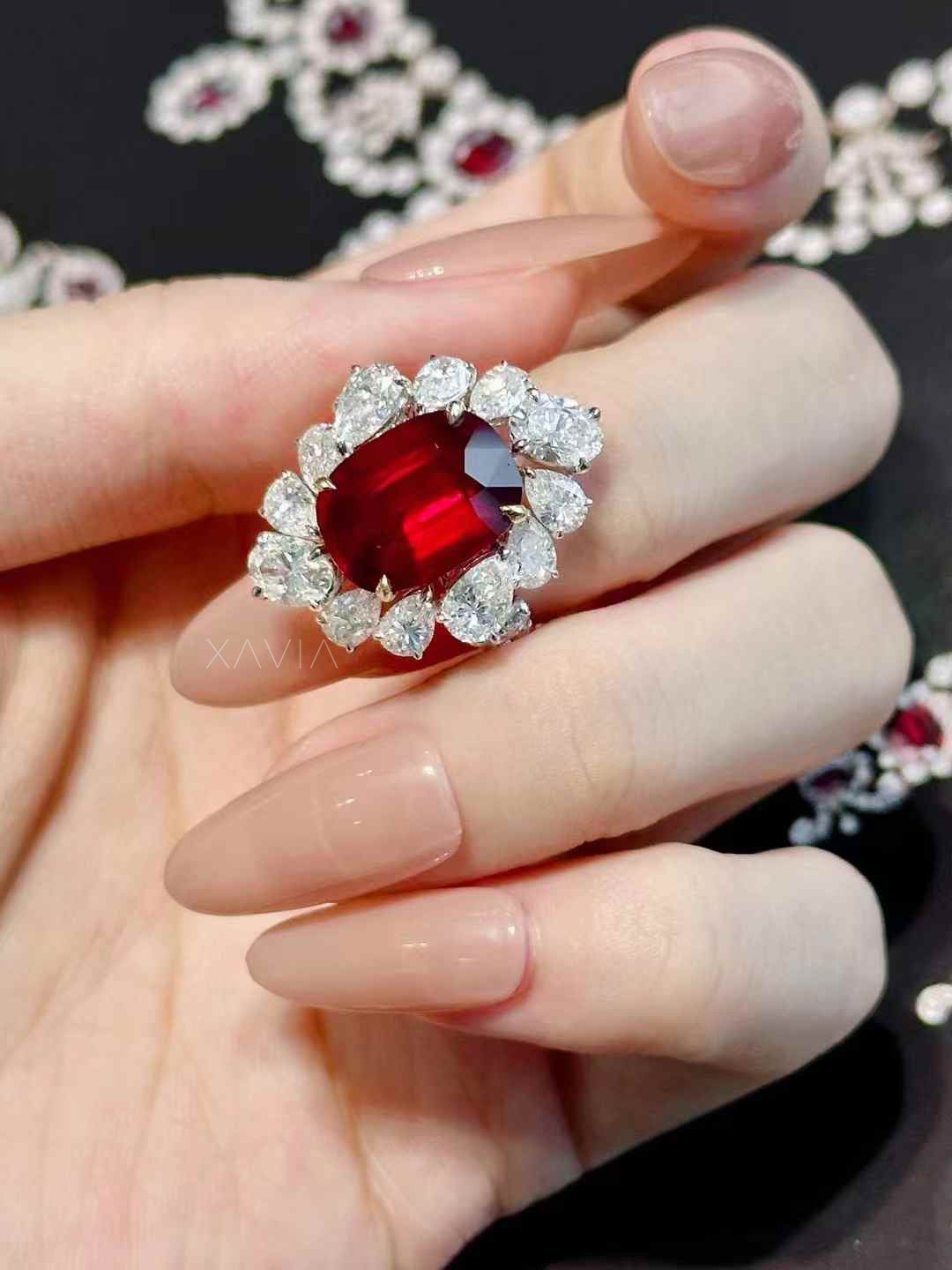 Luxury cushion cut ruby red halo ring featuring pear shaped lab grown diamonds arranged in a floral cluster, photographed in high detail