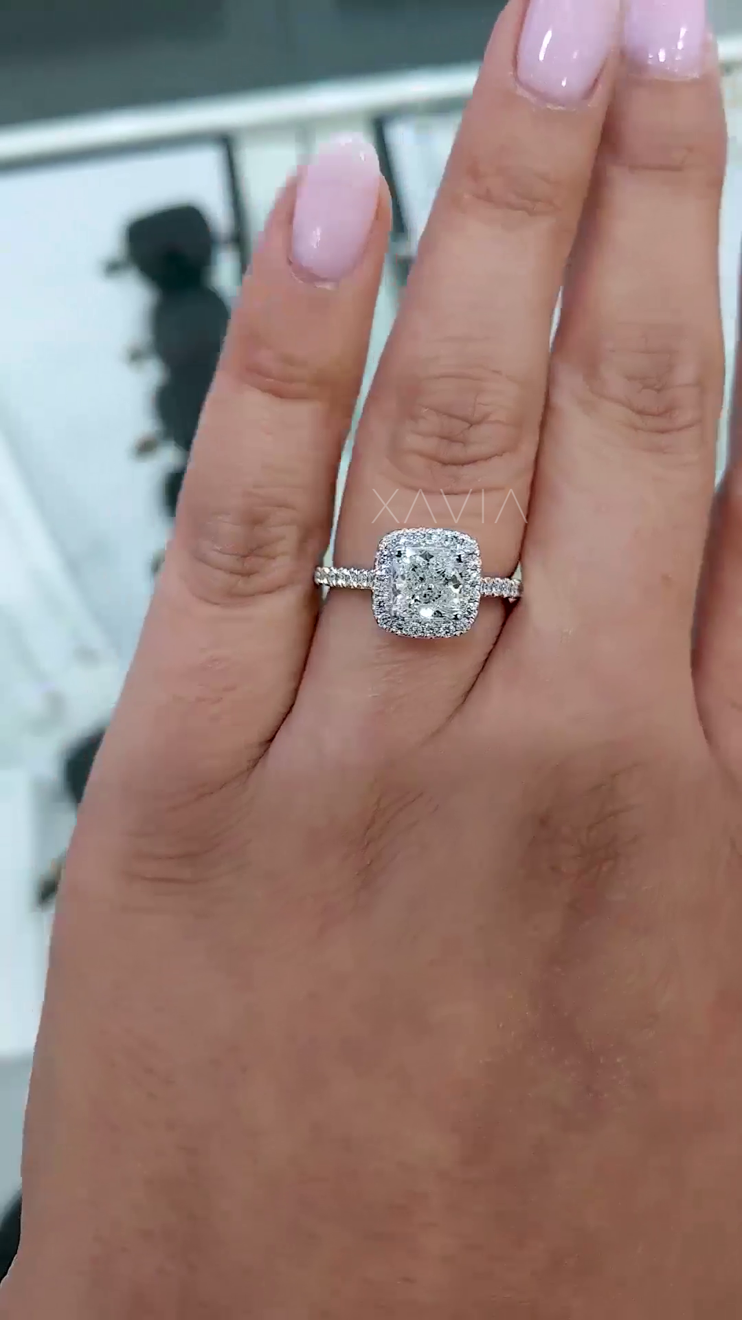 cushion cut lab grown diamond engagement ring with micro pavé halo and slim pavé band shown worn on hand with natural lighting and soft sparkle