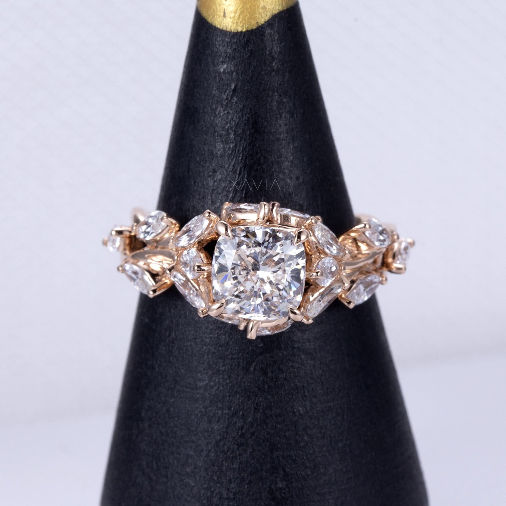 cushion cut lab grown diamond engagement ring on jewelry display stand highlighting marquise and baguette diamond floral cluster design