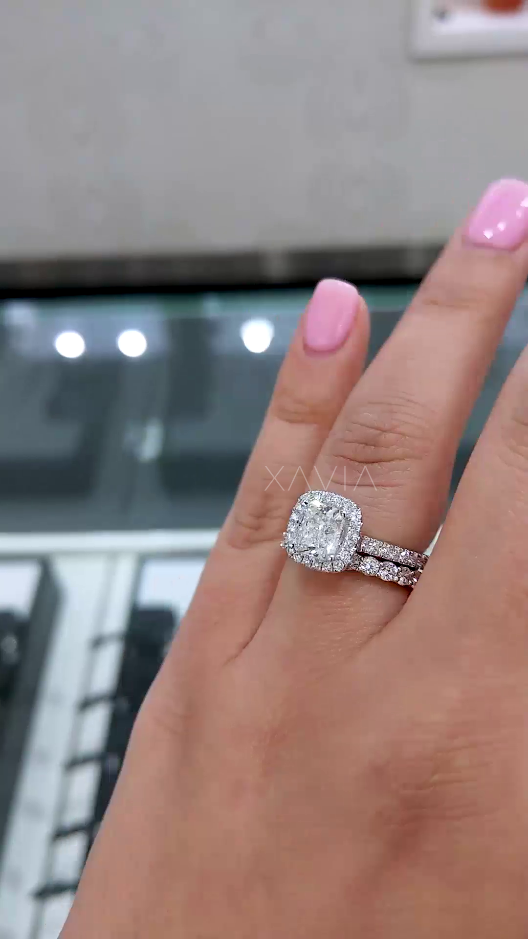 angled perspective of cushion halo diamond ring highlighting split shank design and fine pavé diamonds across band in high polish finish