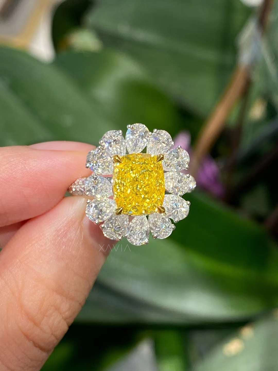 Cushion cut lab grown yellow diamond ring worn on hand, featuring a marquise floral halo, prong setting, and high polish gold craftsmanship