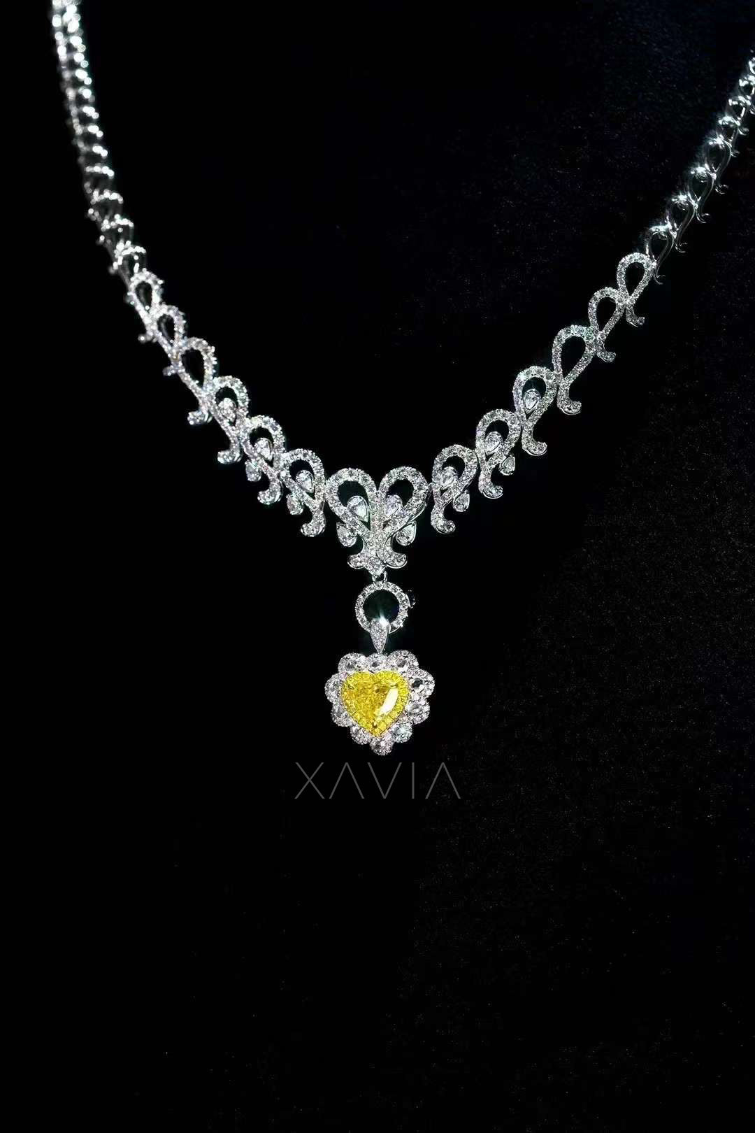 luxury diamond necklace showcasing ornate pavé chain with central heart shaped fancy yellow diamond pendant surrounded by halo of white diamonds