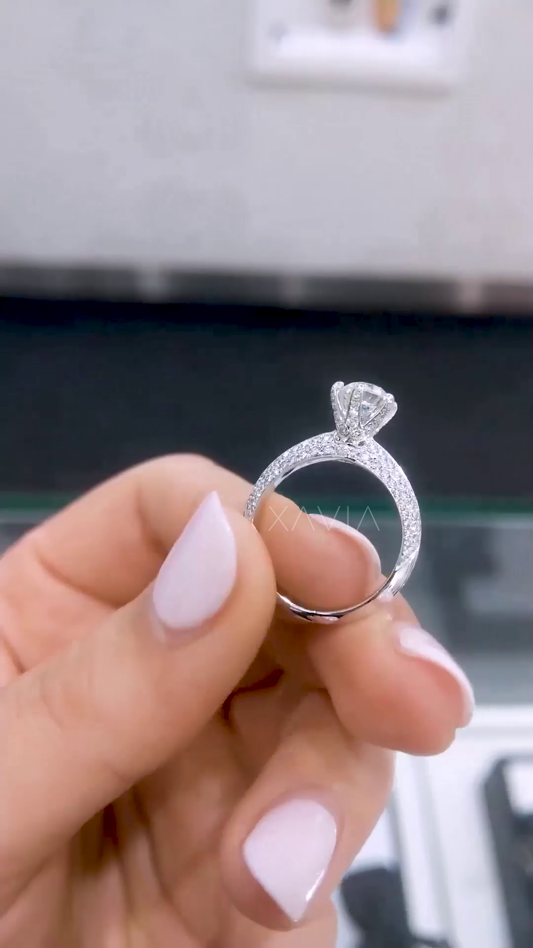 Side angle of round solitaire engagement ring highlighting hidden halo beneath center stone and pavé split band