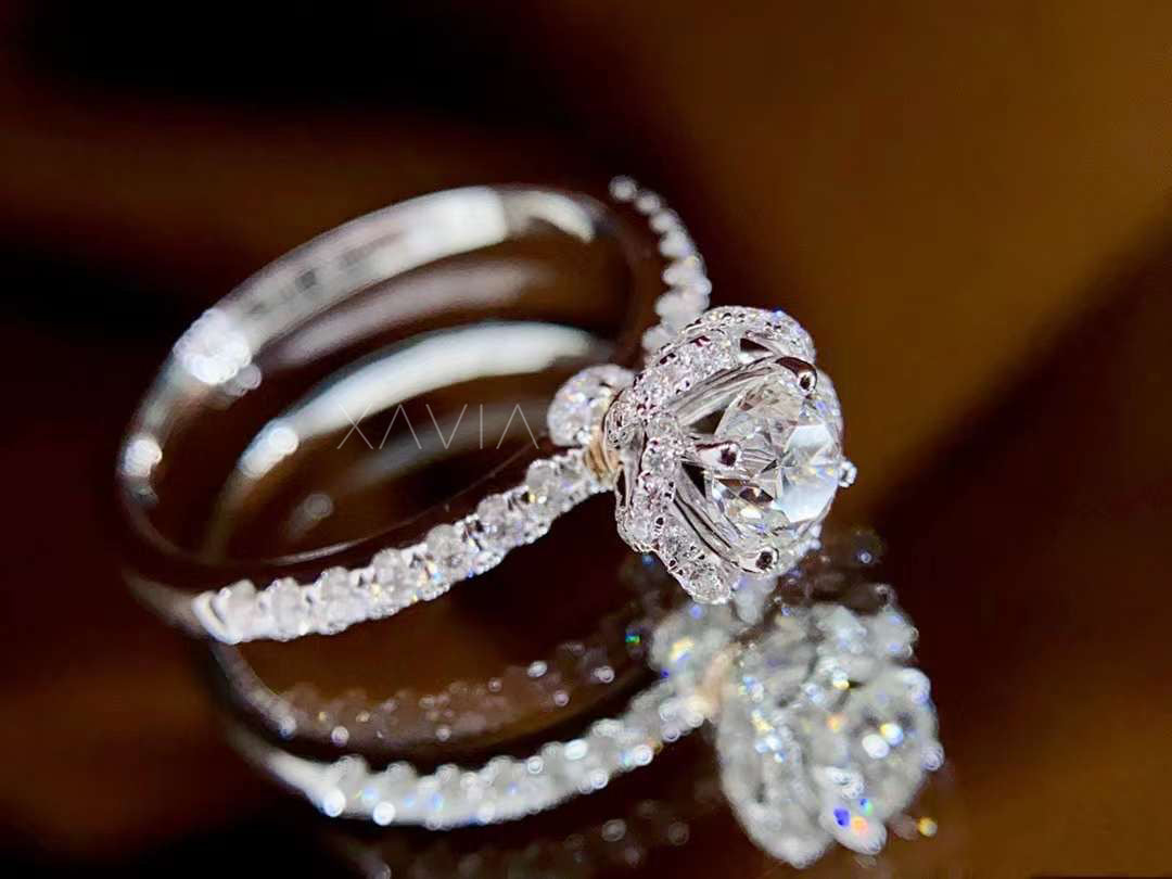 elegant floral halo round diamond engagement ring worn on model’s hand, pavé band sparkling in natural light