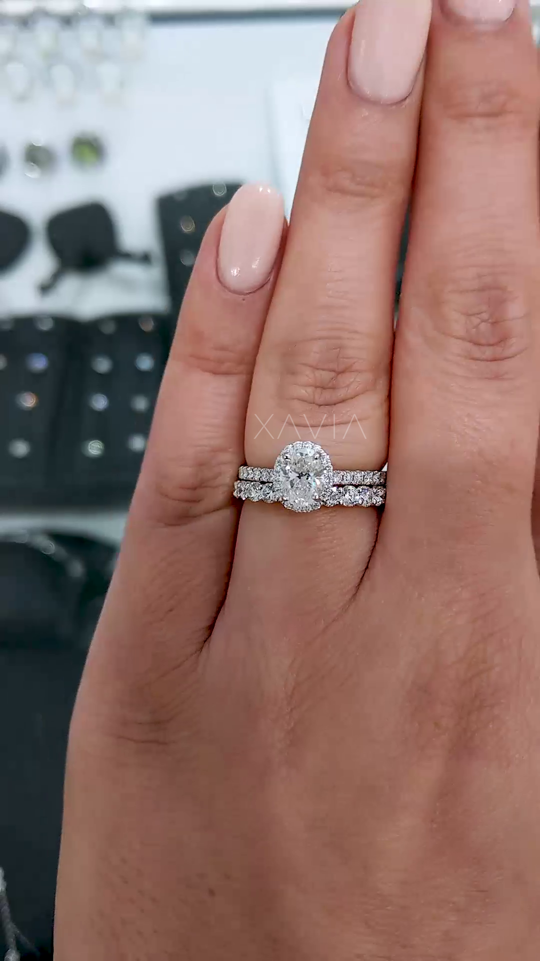 top view of oval diamond halo engagement ring stacked with two pavé bands emphasizing layered bridal look and symmetry