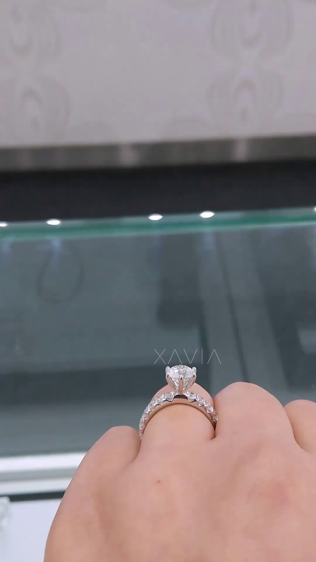 side angle showing elevated crown setting of round brilliant diamond ring with micro pavé band and clean structural detailing