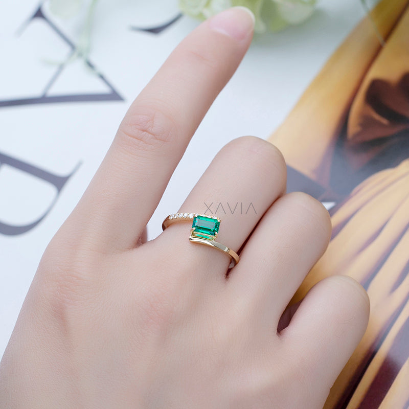 Emerald cut lab grown diamond open band ring worn on hand, showing delicate pavé curve and elegant gold finish