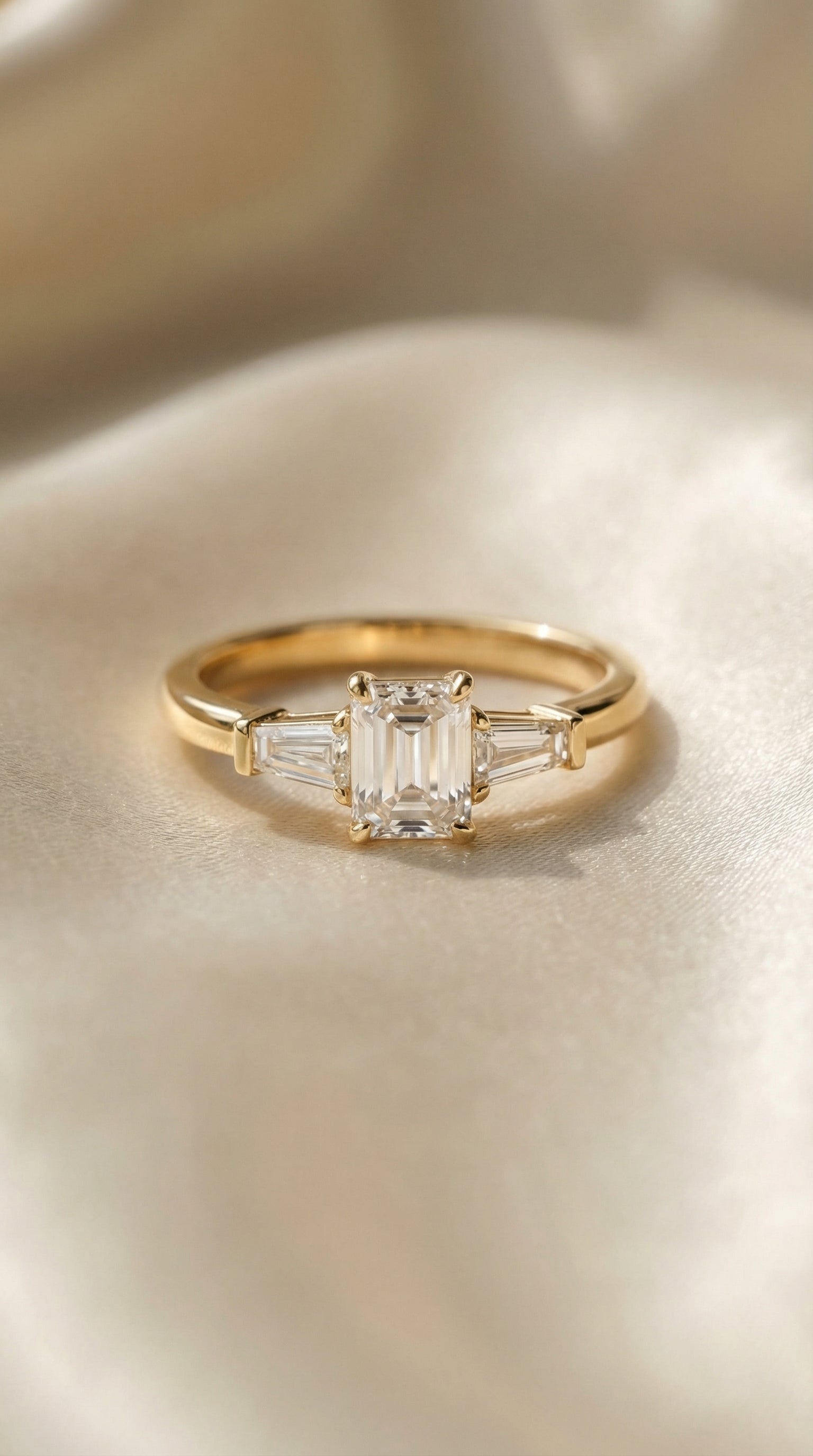 Minimal top view of emerald cut lab grown diamond engagement ring with symmetrical tapered baguette side diamonds and polished gold band