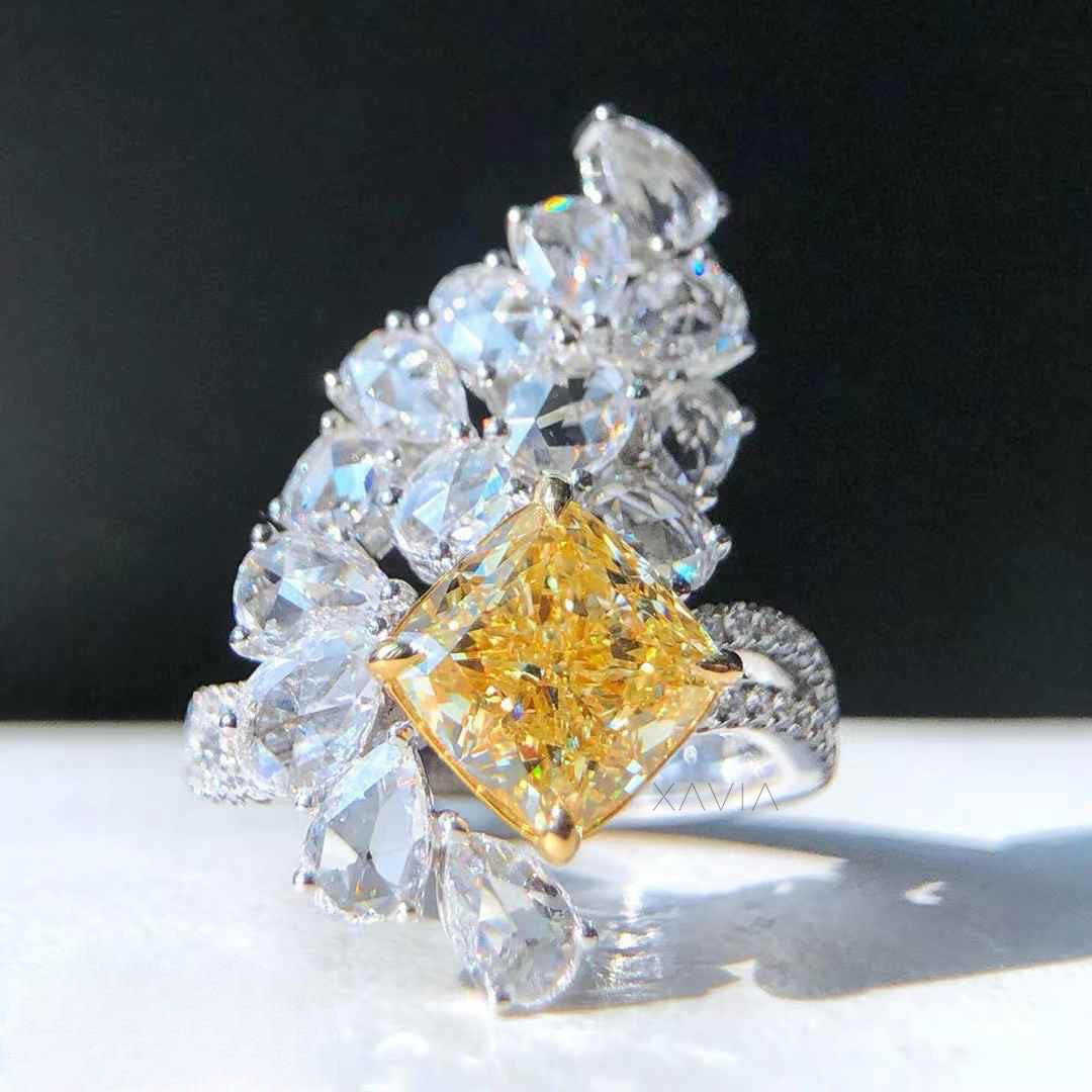 Top angle view of fancy yellow cushion cut lab grown diamond cocktail ring featuring marquise and pear shaped floral halo cluster with pavé split shank band