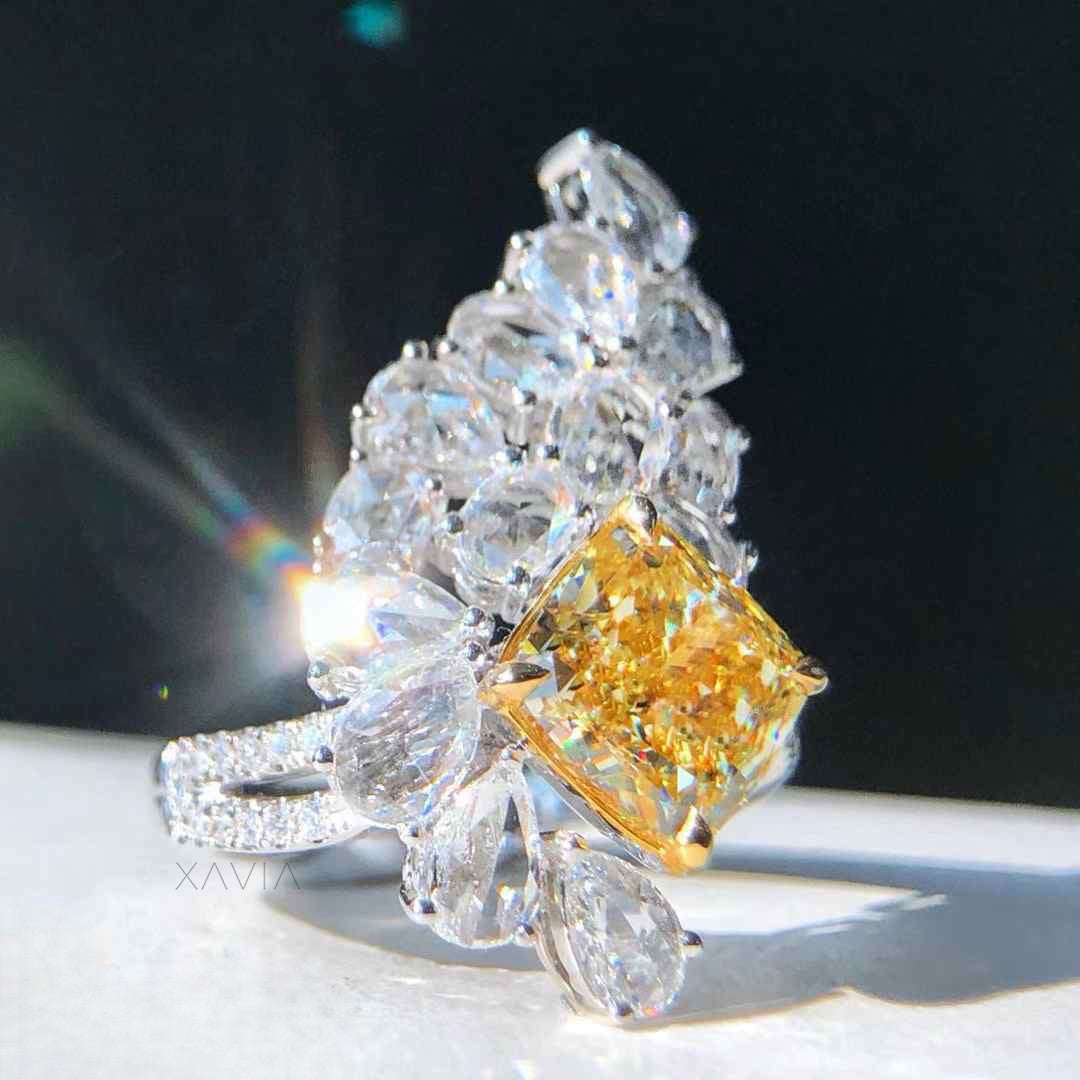 Hand shot of statement fancy yellow cushion cut diamond floral cluster cocktail ring with marquise pear halo diamonds and pavé split shank band