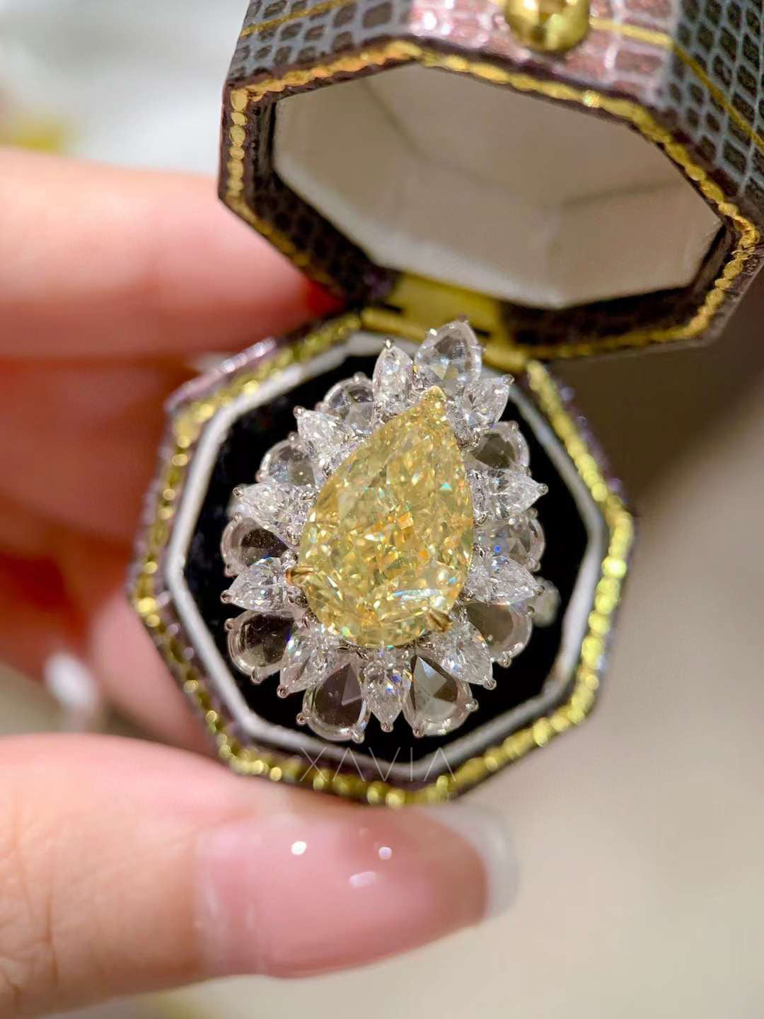 luxury fancy yellow pear cut diamond ring with marquise halo cluster in platinum, photographed in display box