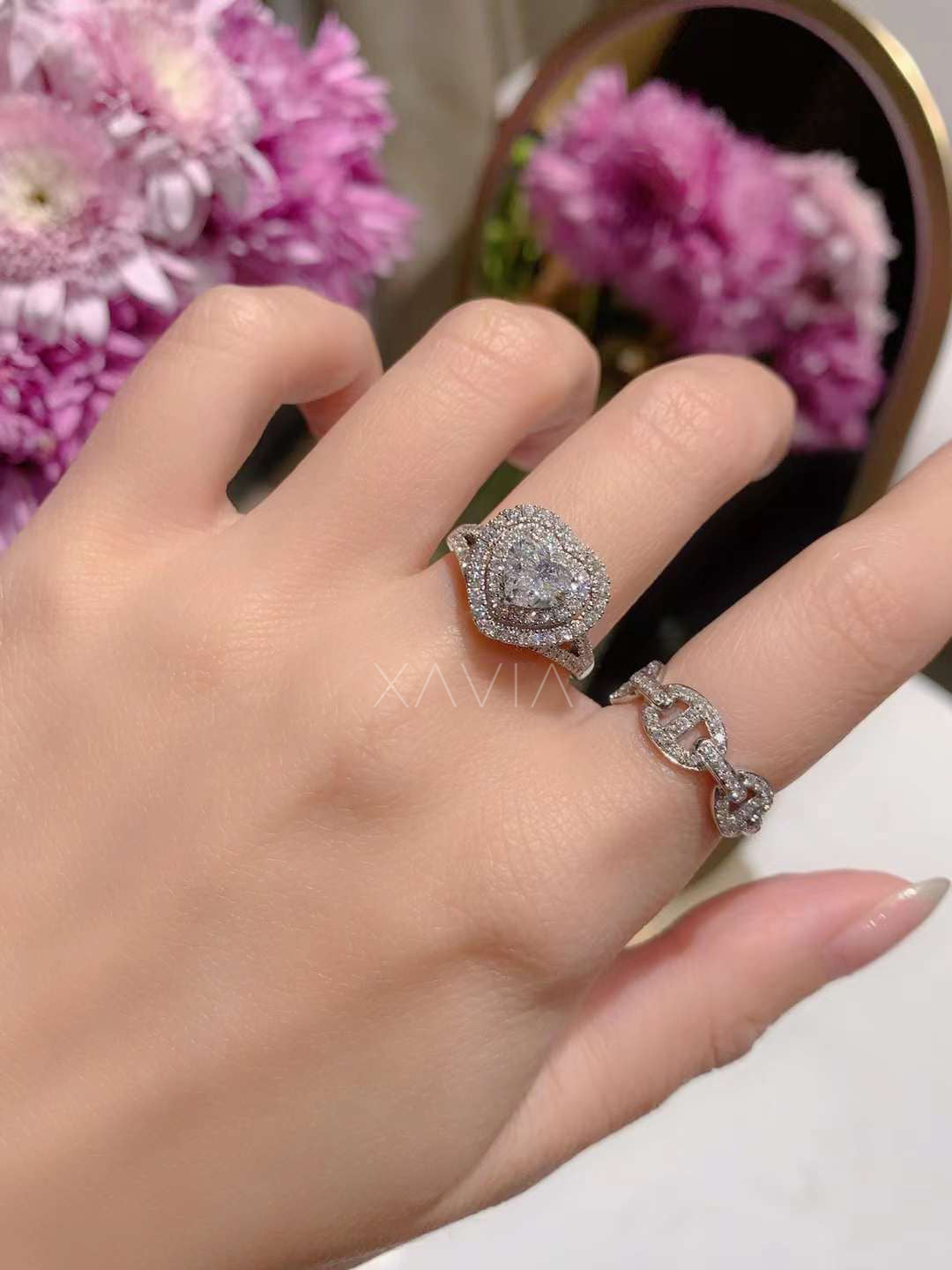 heart cut diamond double halo engagement ring displayed with pink flowers in background for editorial luxury