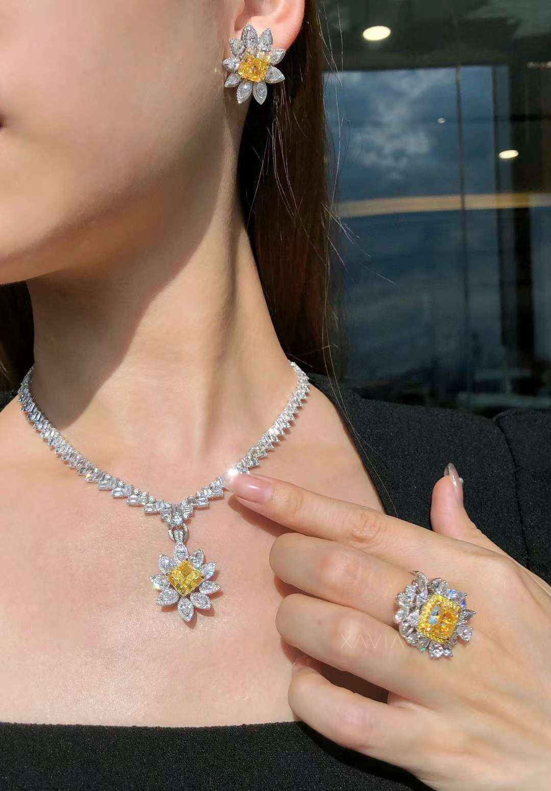 model wearing Heliora yellow radiant diamond floral pendant necklace, matching earrings, and bold cocktail ring