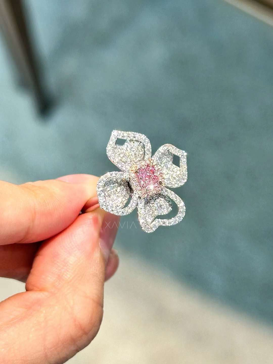 angled view of Petralisse pink center floral diamond ring with pavé-set white diamond petals