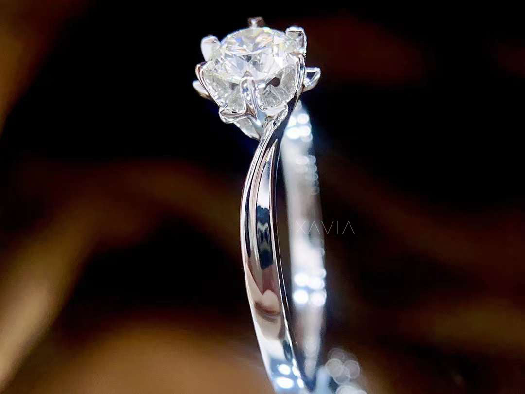 Silver ring with a diamond on a dark background