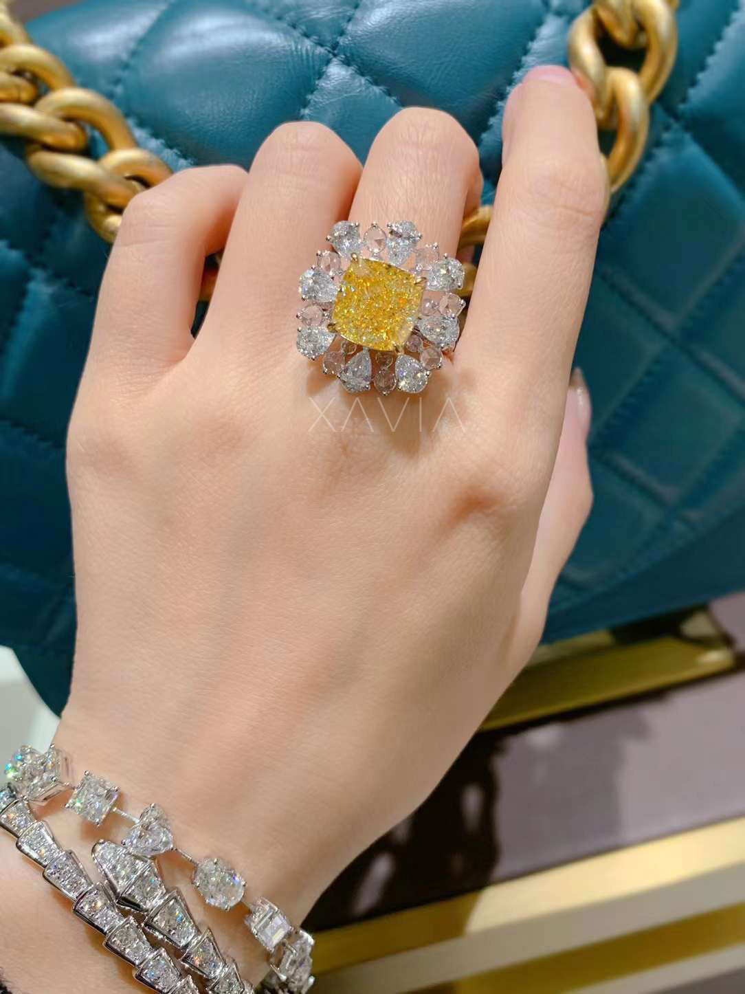 angled macro shot of bold cushion fancy yellow diamond surrounded by pear halo of DEF lab-grown white diamonds in floral cluster setting