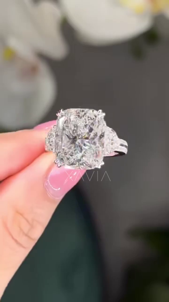 front-facing close-up of cushion cut lab diamond engagement ring with trapezoid side stones and pavé platinum shank