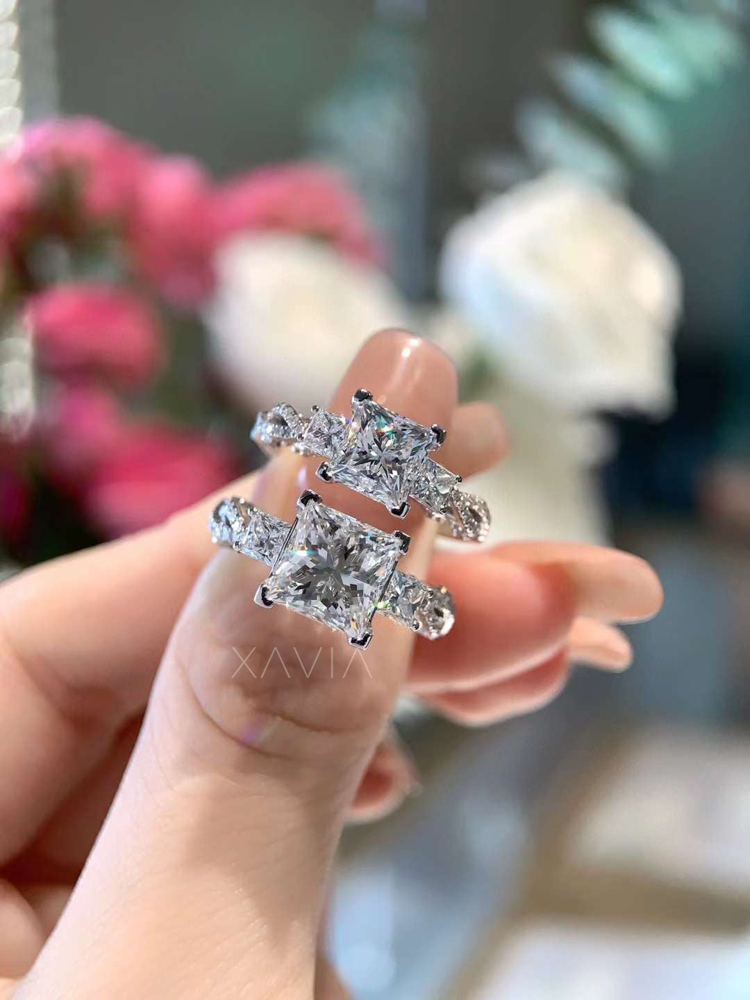 front display of platinum three-stone engagement ring with brilliant princess cut center and matching side diamonds