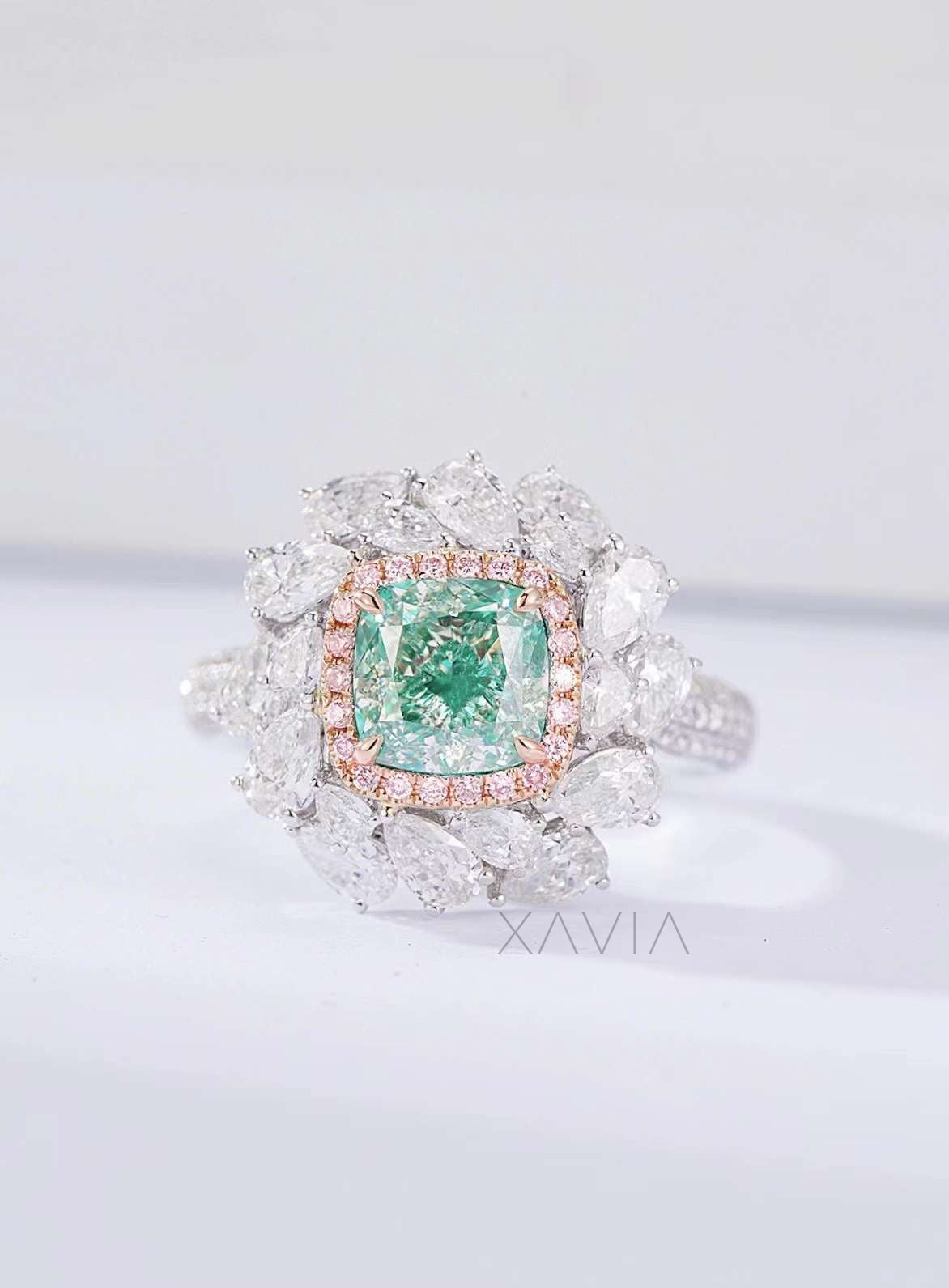 green cushion cut lab diamond ring with pink halo and pear diamond floral cluster in platinum setting