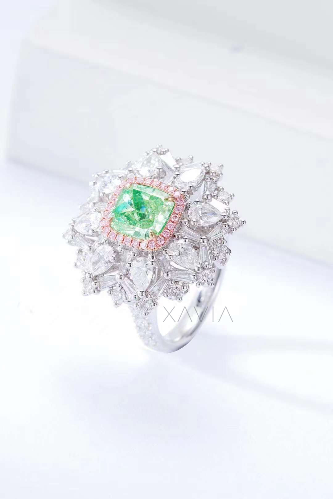 side profile view of cushion cut green diamond halo ring with pavé pink accents and white diamond cluster setting