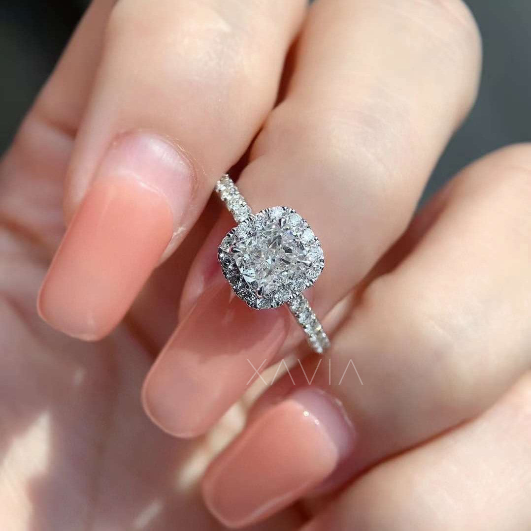 close-up of cushion cut halo diamond ring on fingers