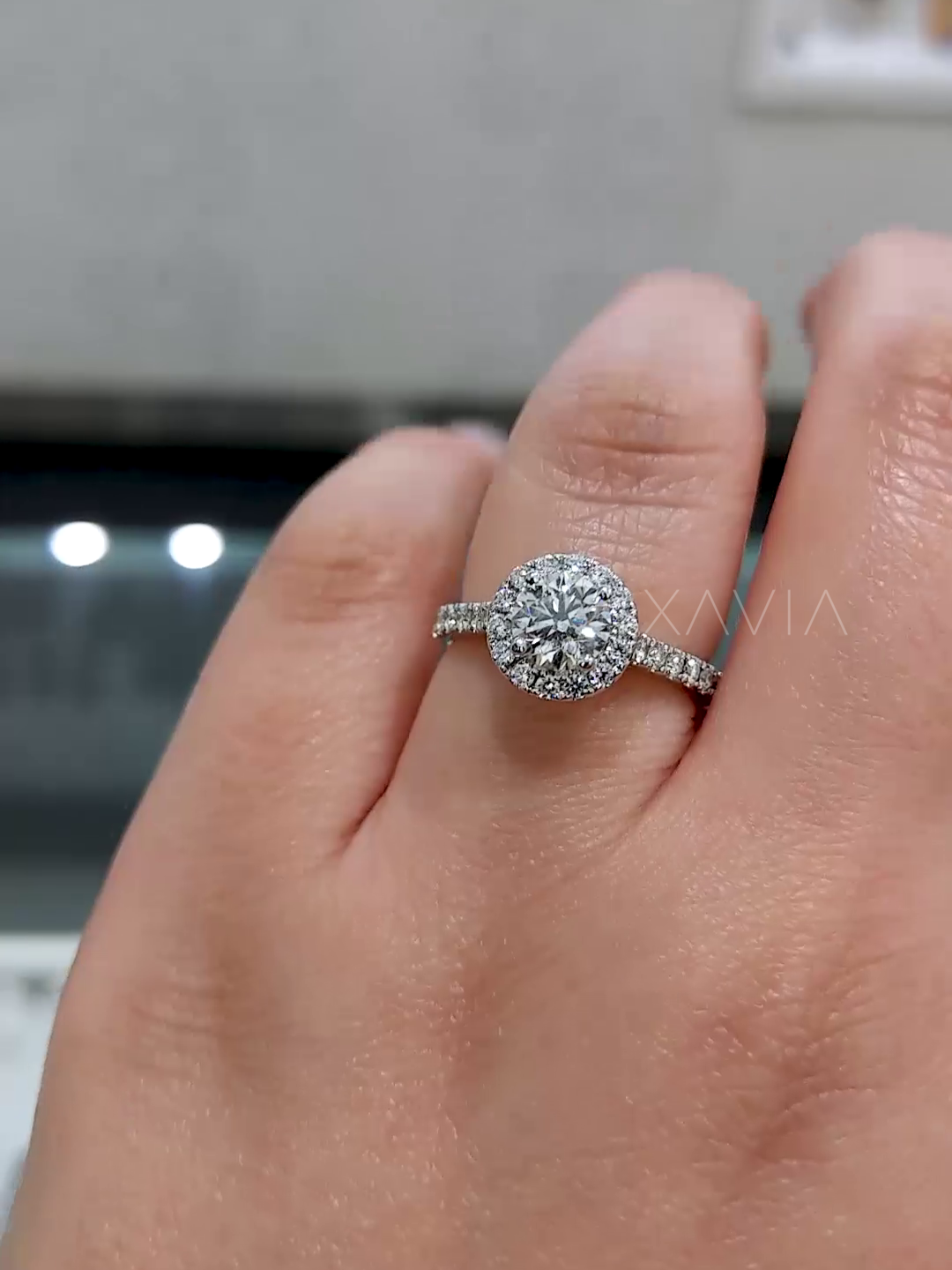 close-up front view of round diamond ring with pavé and halo