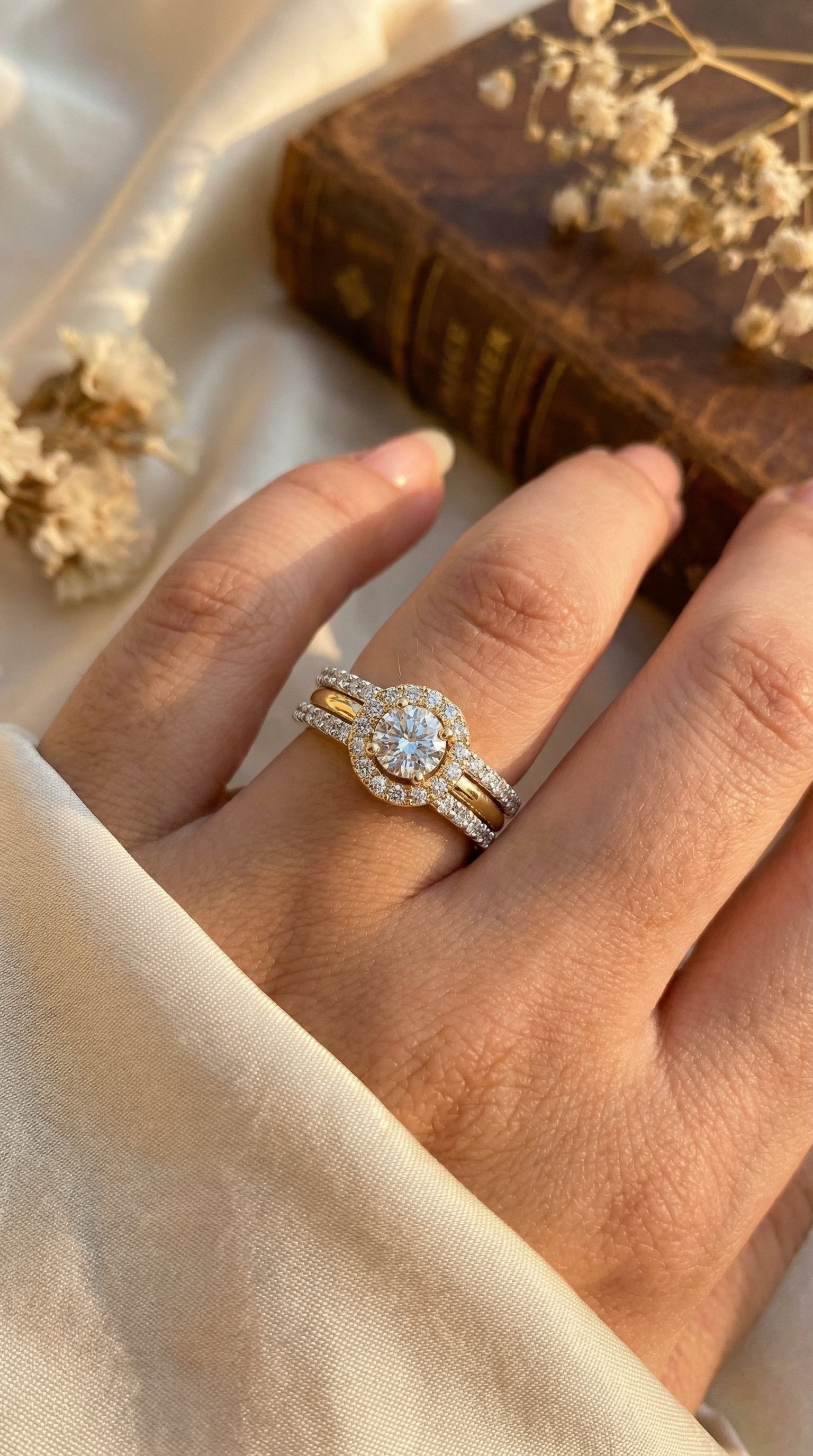 elegant round halo lab grown diamond engagement ring worn on woman hand with split pavé band and two tone gold design in soft natural lighting lifestyle photo