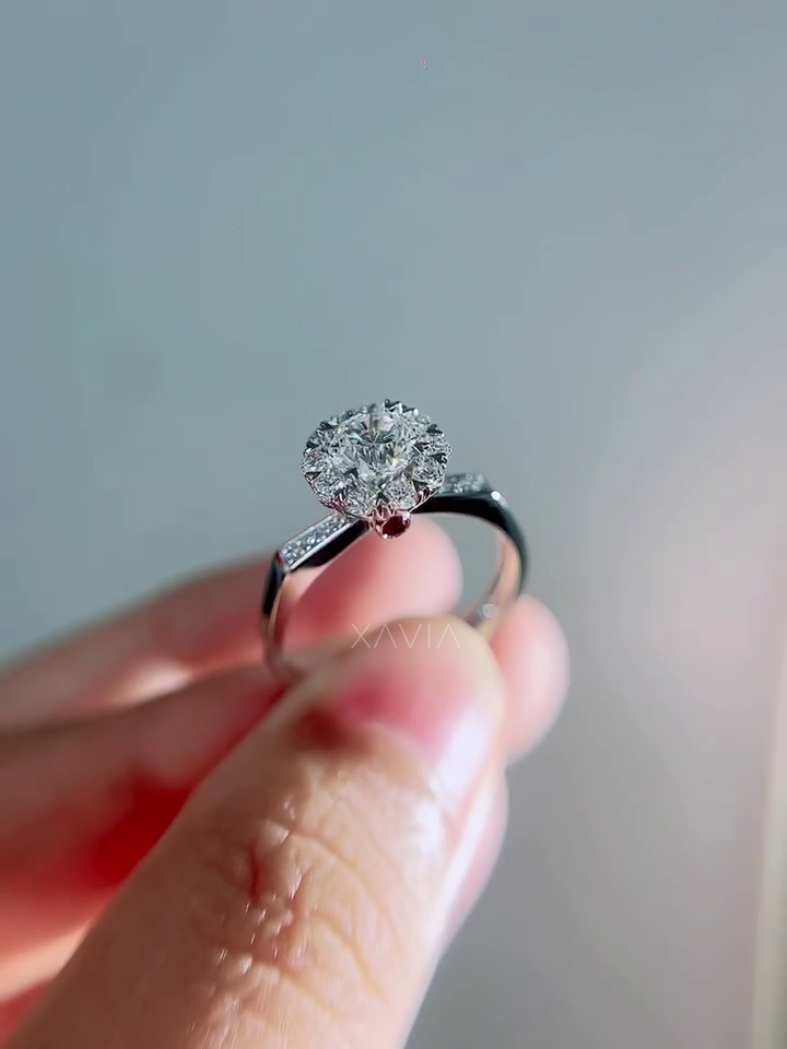 Side profile of floral halo engagement ring revealing hidden ruby accent beneath diamond crown and elegant polished band structure