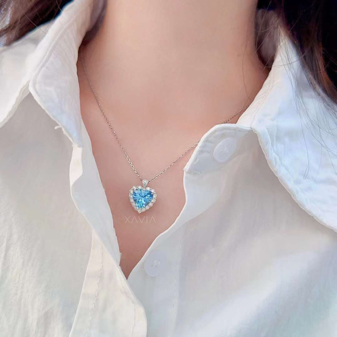 Heart cut ocean blue gemstone diamond halo pendant necklace featuring round brilliant diamond halo and pavé bail set on delicate chain