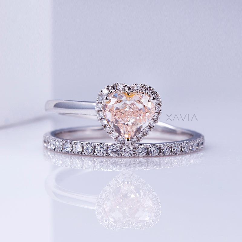 front facing view of heart shaped halo diamond engagement ring paired with pavé eternity wedding band in white gold