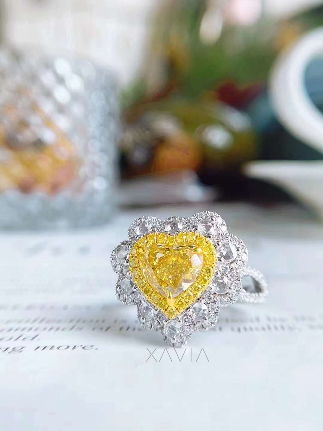 close-up view of heart shaped fancy yellow diamond ring with white diamond halo and pavé band in luxury finish