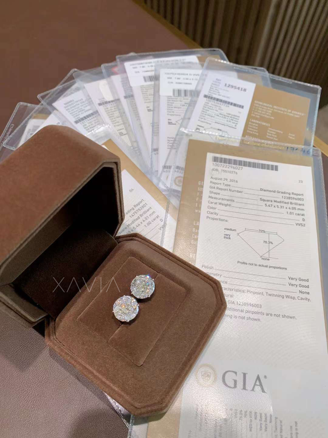 Round illusion diamond studs displayed with GIA certificates