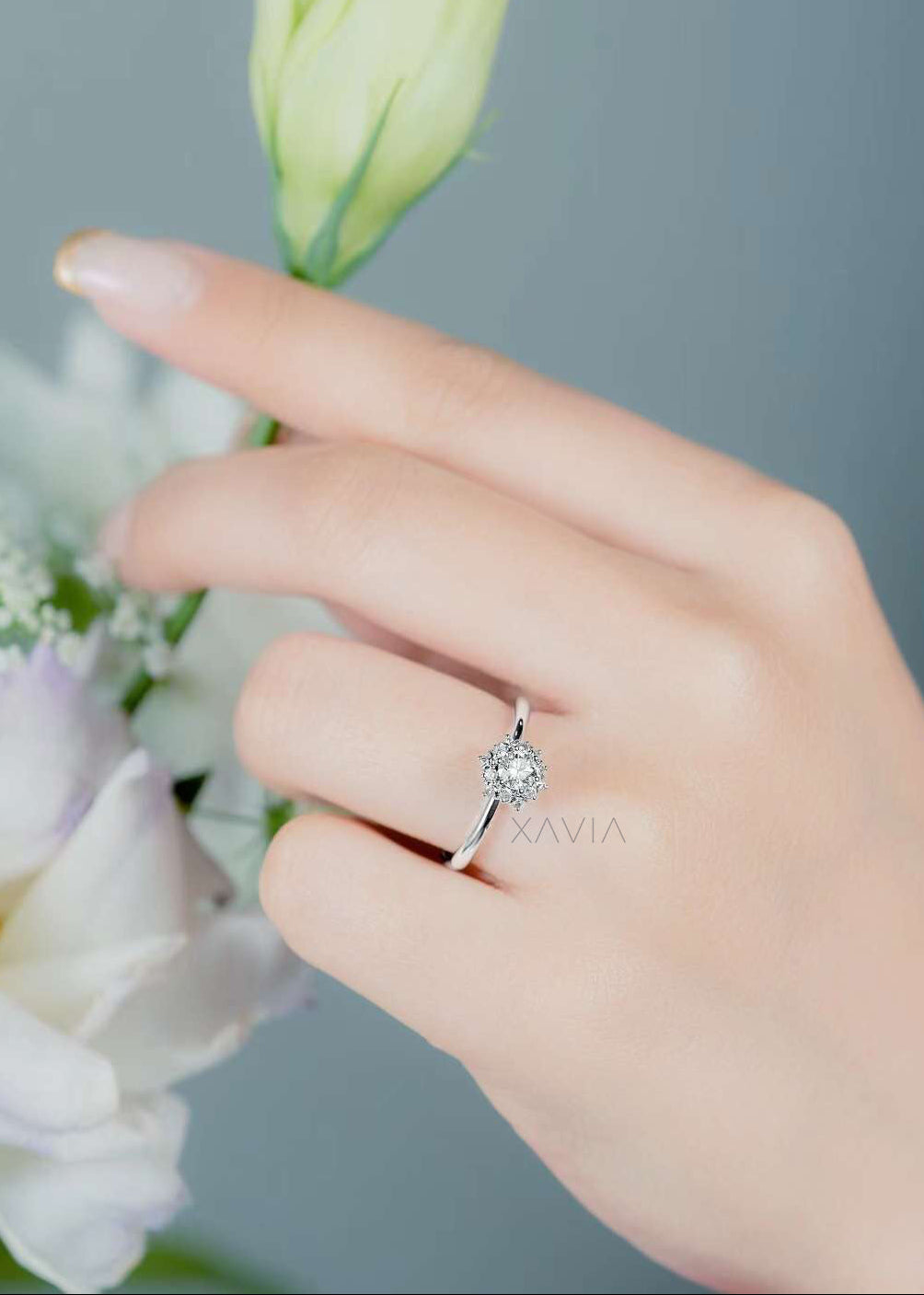 Round cut lab grown diamond halo engagement ring worn on hand highlighting delicate proportions and refined floral sparkle