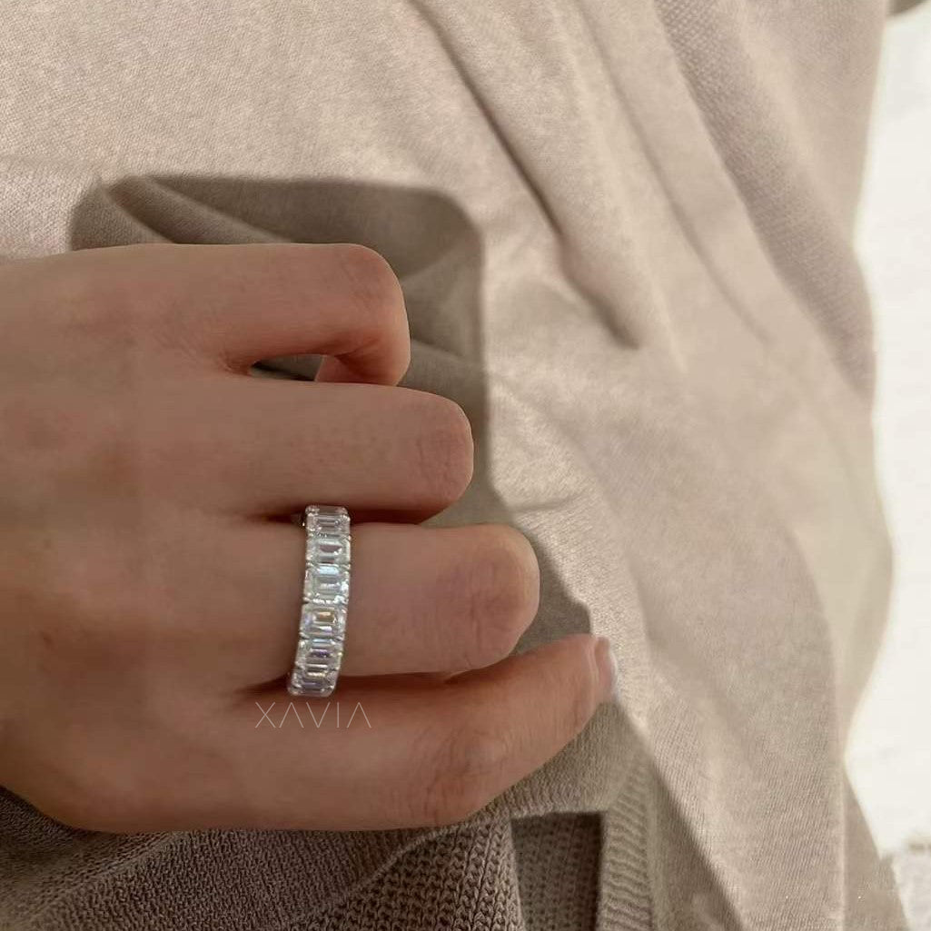 Frontal shot of emerald eternity band on hand, showcasing the bold uniformity and precision alignment of diamonds.