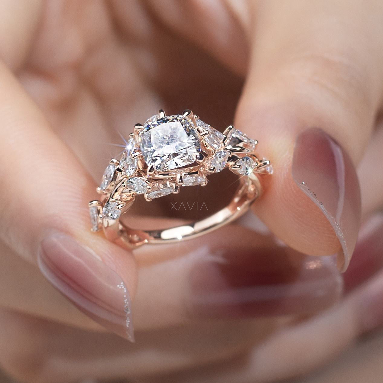 luxury cushion cut lab grown diamond ring held in hand displaying floral cluster diamond design with marquise and baguette side stones